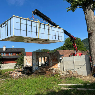 Umisťování bazénu do připraveného výkopu s pomocí hydraulické ruky.